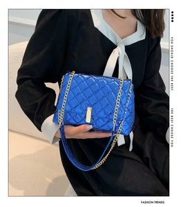 Vue détaillée du sac matelassé bleu métallisé avec chaîne dorée et boucle chic
