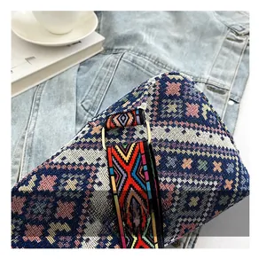 Detailed close-up of woven ethnic shoulder strap with adjustable metal buckle on a bag