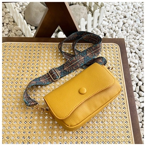 Detail of yellow lychee textured leather bag with ethnic bohemian embroidery strap