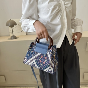 Detail der Vintage-Eimertasche mit geometrischem Webmuster, Holzgriff und Lederklappe