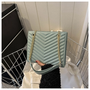 Detail of seafoam green chevron quilted bag with gold chain and leather strap
