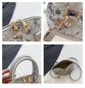 Macro view of shell bag showing bird embroidery, double zippers and metal hardware details