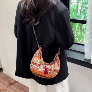 Detail of bohemian crescent bag with ethnic patterns and colorful long tassels