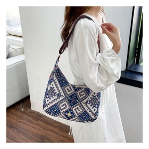 Gros plan sur un sac bandoulière tissé ethnique aux motifs géométriques et large bandoulière