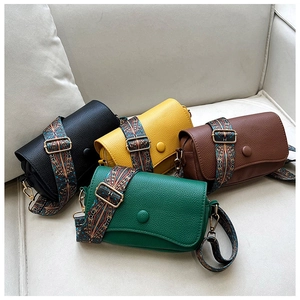 Detail of four colorful crossbody bags with ethnic embroidery straps and leather texture
