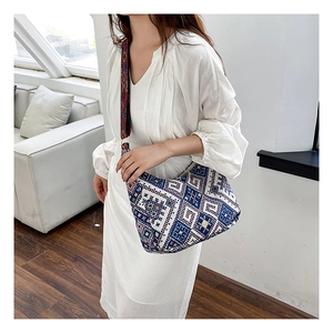 Gros plan sur un sac bohème à motif tissé bleu et large bandoulière jacquard colorée