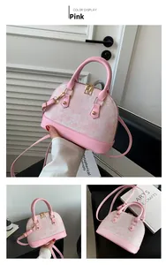 Close-up of pink shell bag featuring jacquard floral fabric and gold rivet details
