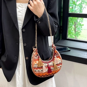 Close-up of ethnic style crescent bag with colorful weaving and hanging tassels