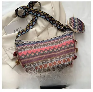 Close-up of ethnic woven tote bag with colorful wave patterns and red fringe accents