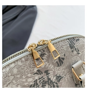 Detailed macro view of golden double zippers and grey jacquard fabric with floral patterns