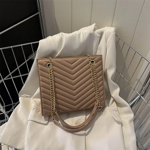 Chic khaki V-quilted chain shoulder bag with gold hardware placed on a white blazer