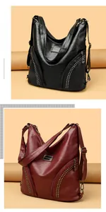 Detail of studded faux leather bags in black and wine red with decorative zippers