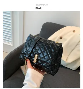Détail du sac en cuir verni matelassé noir avec fermoir rectangulaire en métal doré