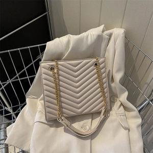 Chic beige chevron quilted chain bag on white blazer in a metal shopping cart