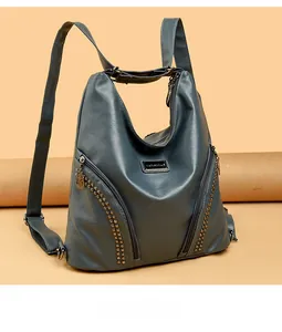 Detail of vintage navy blue faux leather backpack with metallic rivets and top handle