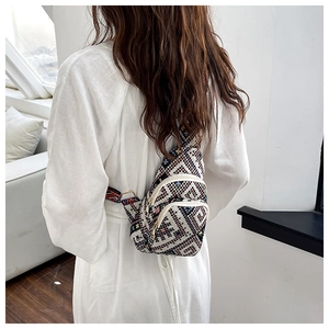 Close-up of bohemian geometric crossbody bag with ethnic woven strap and gold metal zipper