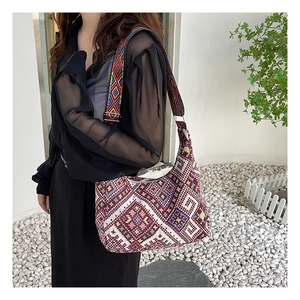 Détail du sac bandoulière bohème tissé avec large sangle brodée aux motifs colorés