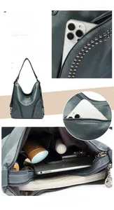 Detail view of large grey-blue hobo bag featuring silver rivets and multiple zipper pockets