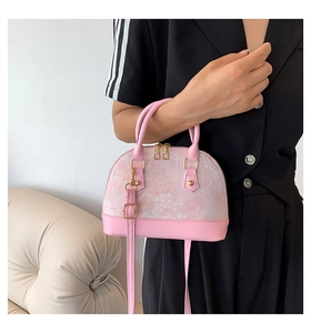 Pink shell handbag with embroidered fabric, leather base and adjustable shoulder strap