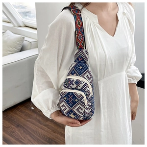 Detail of ethnic geometric patterned chest bag with wide colorful woven shoulder strap