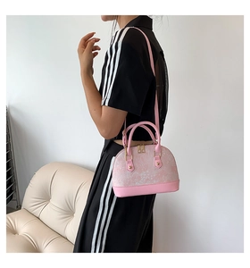 Pink shell bag featuring floral jacquard fabric with stud details on a stylish shoulder strap