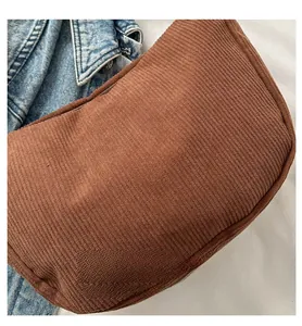 Detailed close-up of brown corduroy fabric texture and zipper closure on shoulder bag