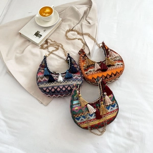 Detail of bohemian crescent hobo bags with ethnic patterns, tassels and gold chains