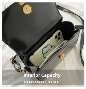 Detail view of black faux leather crossbody bag interior showing phone and glasses storage