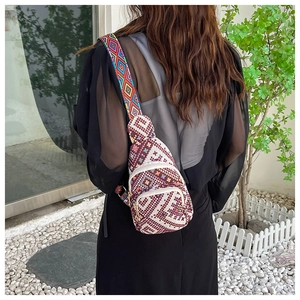 Detailed back view of an ethnic crossbody bag with dual zippers and a wide geometric strap