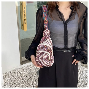 Detail of bohemian woven chest bag with colorful geometric patterns and wide strap