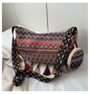 Close-up of ethnic woven tote bag with colorful waves and decorative fringe tassels