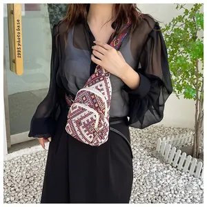 Close-up of ethnic woven crossbody bag featuring geometric patterns and wide jacquard strap