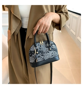 Fashionable shell handbag with white wavy pattern carried by a model in a trench coat