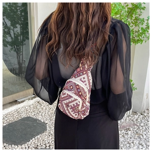 Detail of bohemian ethnic crossbody bag with geometric patterns and wide shoulder strap