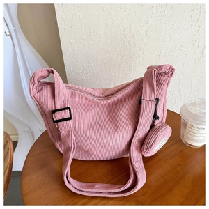 Pink corduroy crossbody bag detail showing adjustable strap and small round coin purse