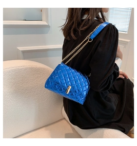 Détail du sac matelassé bleu brillant avec chaîne dorée et fermoir métallique