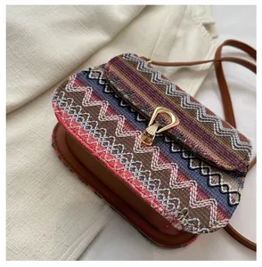 Detail of ethnic crossbody bag with colorful woven pattern and golden metal clasp lock