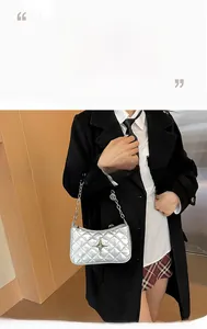 Close-up of silver quilted crossbody bag with star emblem and metal chain strap