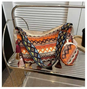 Detail of bohemian woven tote bag with geometric patterns, tassels, and matching round pouch