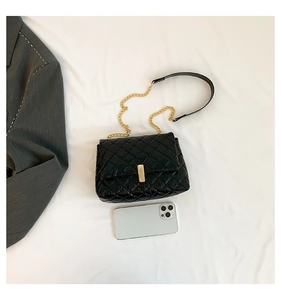 Détail du sac bandoulière matelassé noir avec fermoir doré et bandoulière chaîne