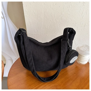 Detail of black corduroy crescent bag with matching small round coin purse accessory
