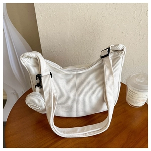 Detail of off-white corduroy hobo bag texture with a mini round coin purse attached