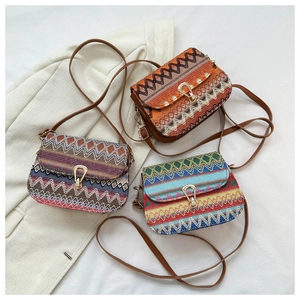 Detailed view of colorful woven ethnic shoulder bags with golden metal drop locks