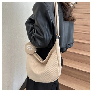 Detail of beige corduroy crossbody crescent bag with matching round coin purse