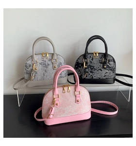 Three embroidered shell bags in grey, black and pink with golden hardware details