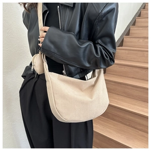 Close-up of beige corduroy hobo bag texture with matching round coin purse detail