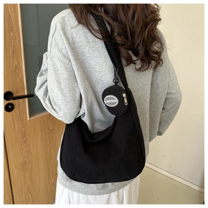 Detail of black corduroy crescent bag with small round pouch and adjustable strap