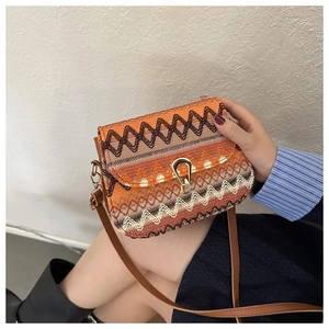 Detail of bohemian woven crossbody bag with geometric patterns and golden U-shaped buckle