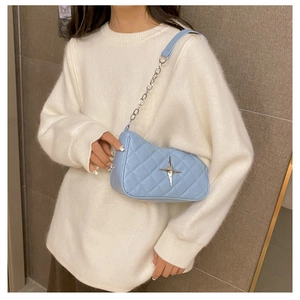 Detail of light blue quilted crossbody bag featuring a silver star metal ornament