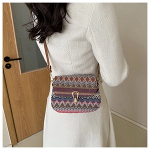Detail of bohemian woven crossbody bag with colorful wave patterns and U-shaped buckle